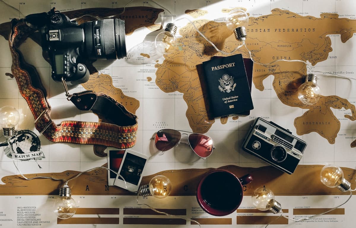 Pasaporte, cámara y documentos de viaje sobre una mesa